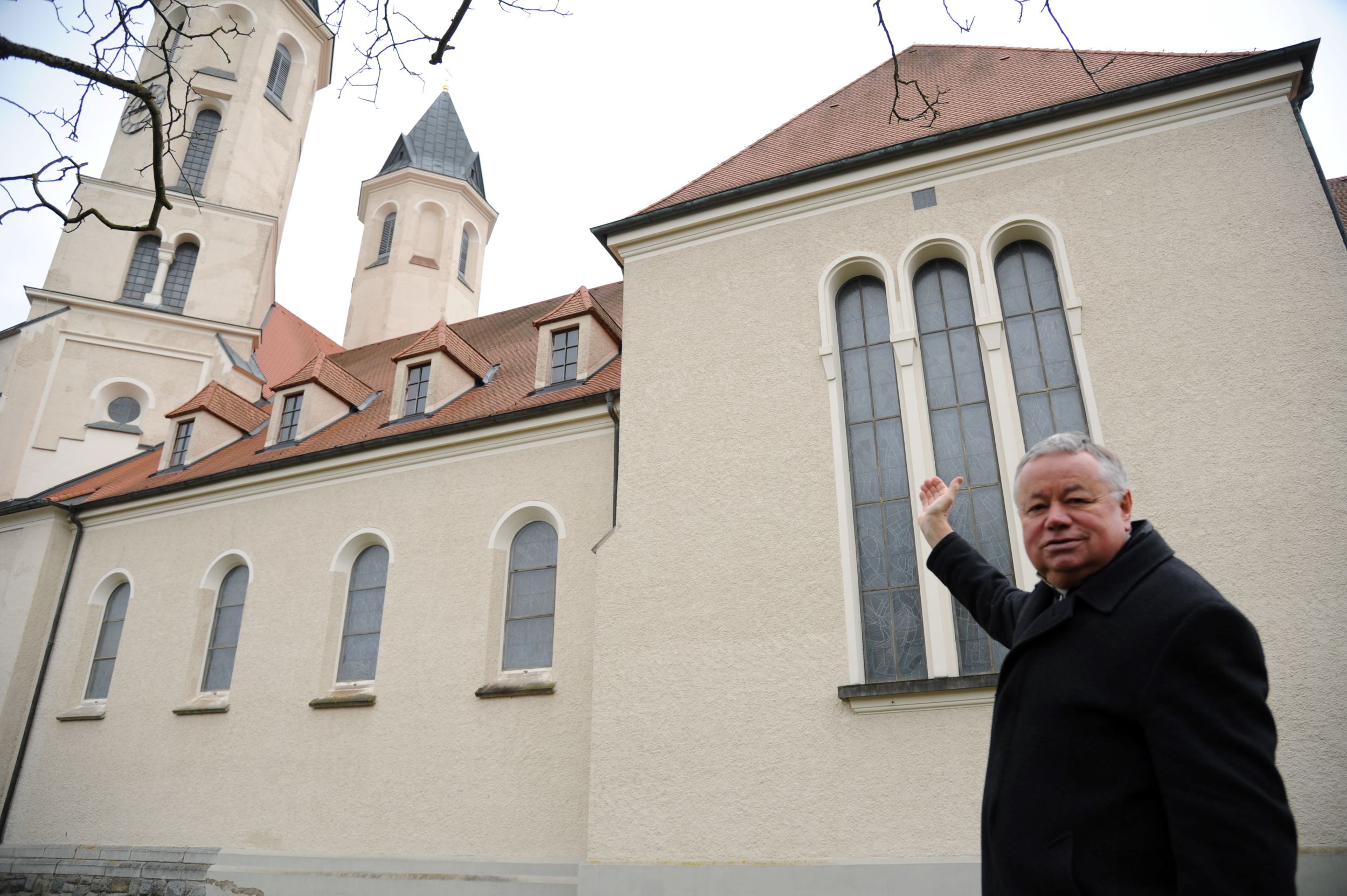 Pfarrer P. Hermann Sandberger zeigt auf jene Stelle, in der am 20. März 1945 eine Bombe eingeschlagen hat.